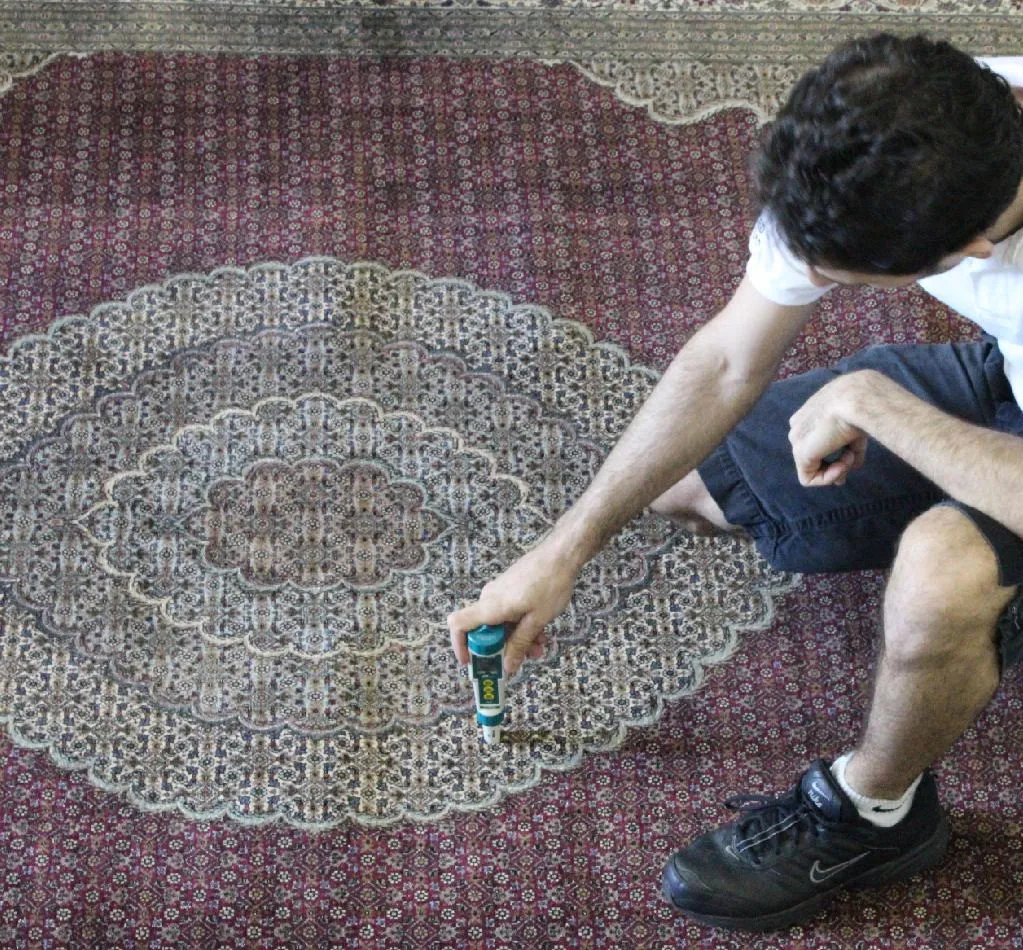 Close-up of a pH meter taking a reading on a rug before washing